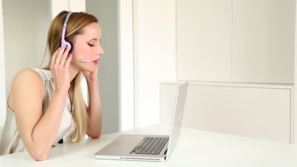 Γυναίκα με ακουστικά για τον υπολογιστή, μιλάει στον πελάτη — Αρχείο Βίντεο