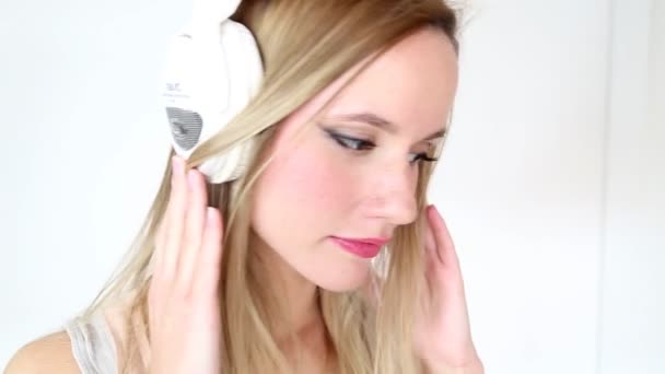 Mujer escuchando música con auriculares blancos — Vídeos de Stock