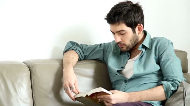 Man reading book in living room — Stock Video