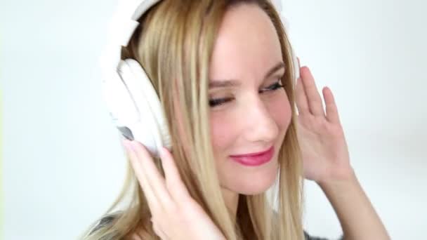 Nő a fehér fejhallgató zenét hallgatni — Stock videók