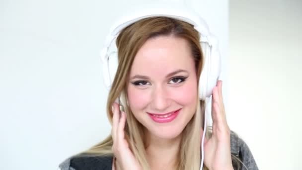 Mulher ouvindo música com fones de ouvido brancos — Vídeo de Stock