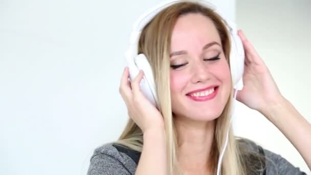 女性の白いヘッドフォンで音楽を聴く — ストック動画