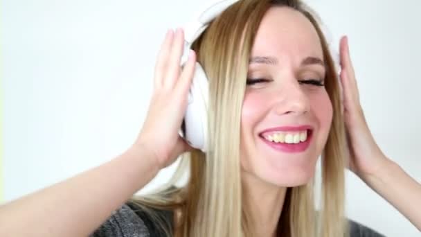 Mujer escuchando música con auriculares blancos — Vídeos de Stock