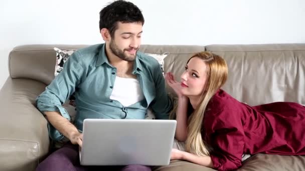 Pareja de surf en el ordenador portátil en la sala de estar — Vídeos de Stock