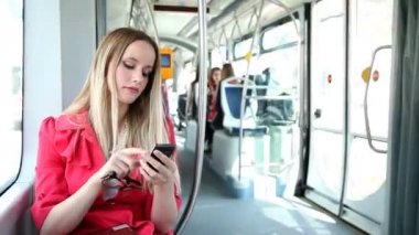 Tramvayda cep telefonu kullanan kadın