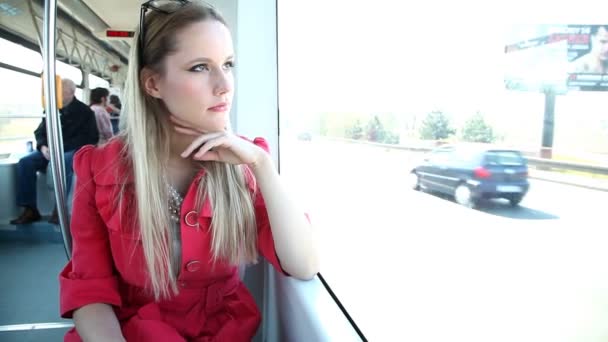 Женщина едет в трамвае и смотрит в окно — стоковое видео