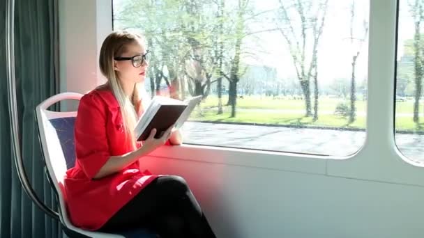 Frau liest Buch in Straßenbahn — Stockvideo