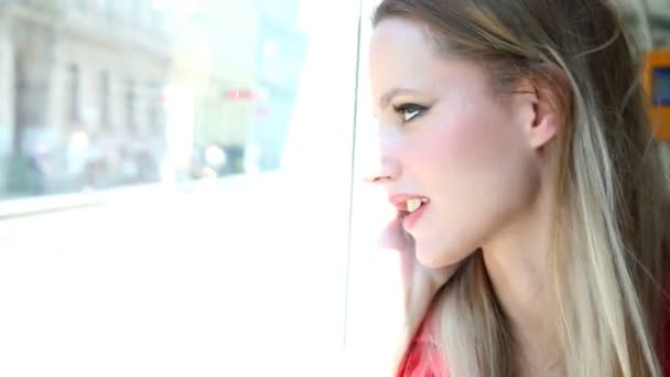 Hermosa mujer rubia sentada en tranvía y hablando por teléfono — Vídeos de Stock