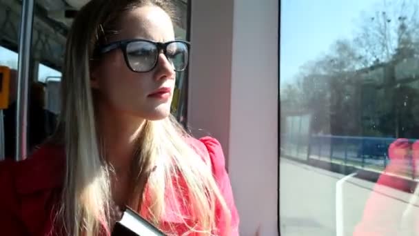 Woman holding the book on tram — Stock Video