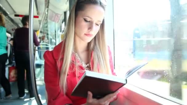 Mujer sentada y leyendo en el tranvía — Vídeo de stock