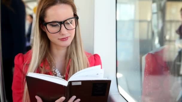 Mujer sentada y leyendo en el tranvía — Vídeo de stock