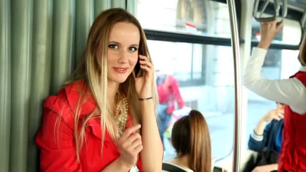 Женщина в трамвае разговаривает по телефону — стоковое видео