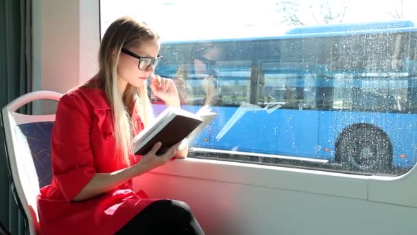 Frau liest Buch in Straßenbahn — Stockvideo