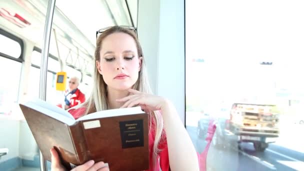 Frau liest Buch in Straßenbahn — Stockvideo