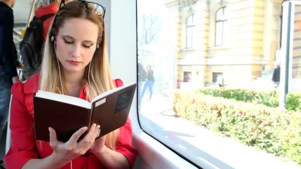 Woman  reading book on tram — Stock Video