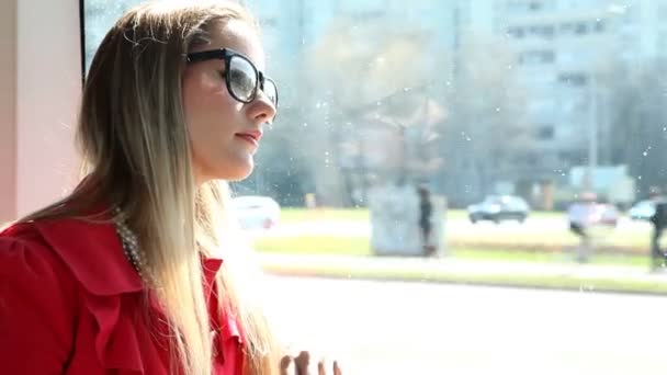 Жінка їде в трамваї і дивиться у вікно — стокове відео