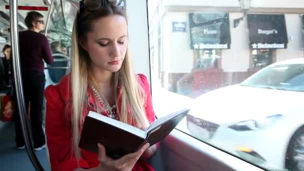 Woman reading book in tram — Stock Video