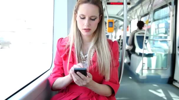 Kobieta przy użyciu telefonu komórkowego na tramwaj — Wideo stockowe
