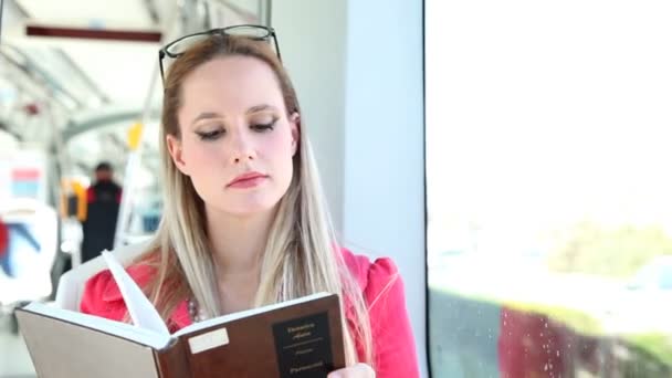 Woman reading book on tram — Stock Video