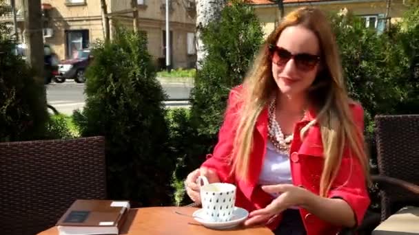 Vrouw zitten in koffie winkel — Stockvideo