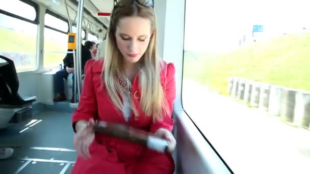 Frau in Straßenbahn greift nach Buch — Stockvideo