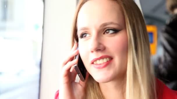 Mooie blonde vrouw zitten in de tram en praten over de telefoon — Stockvideo