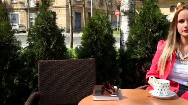 Жінка сидить на стільці в кав'ярні — стокове відео