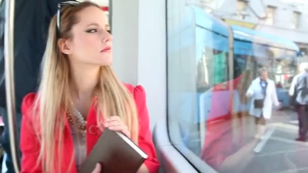 Vrouw bedrijf boek over tram — Stockvideo