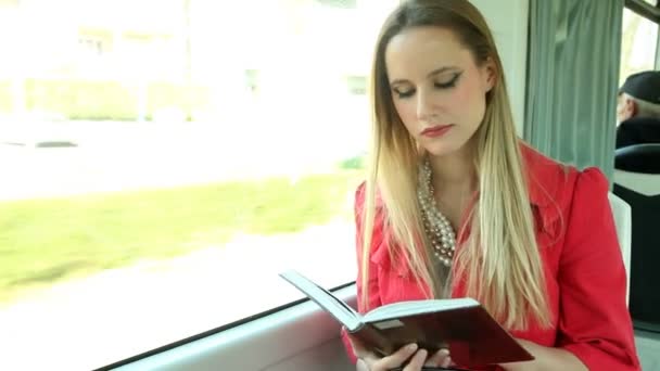 Woman reading book on tram — Stock Video