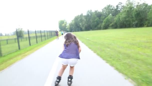 若いです魅力的な女性rollerbladingで公園で美しい晴れた日に. — ストック動画