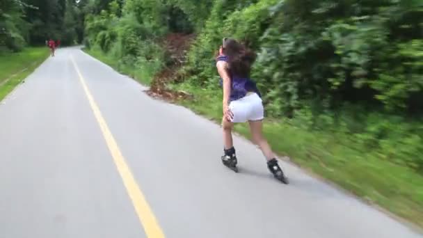 Молодая привлекательная женщина катается на роликах в парке — стоковое видео