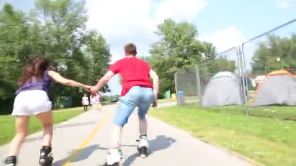 Vrouw en man skaten op een zonnige dag in park — Stockvideo