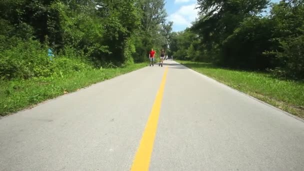 Ζευγάρι rollerbladers πατινάζ προς την κάμερα στο πάρκο. — Αρχείο Βίντεο