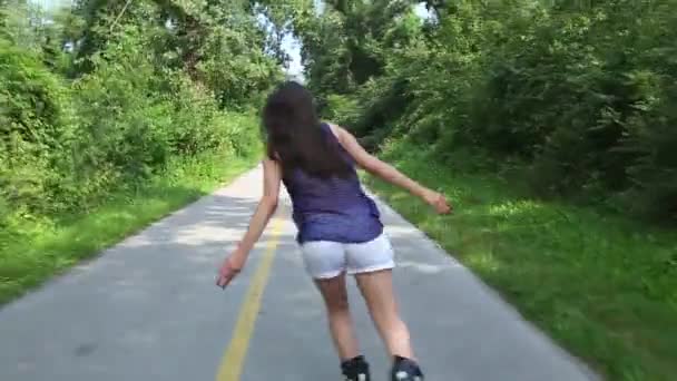 Молодая привлекательная женщина катается на роликах в парке в прекрасный солнечный день . — стоковое видео