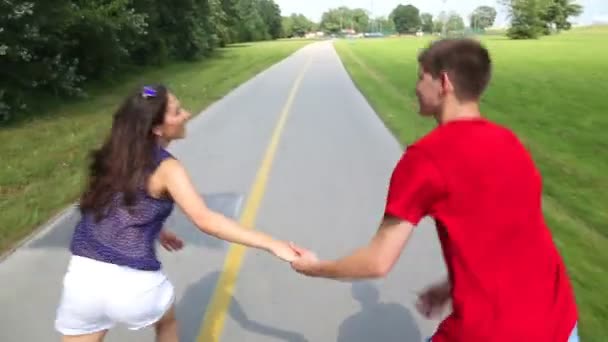 Woman and man rollerblading on a sunny day in park — Stock Video