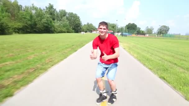 Young handsome man rollerblading in park — Stock Video