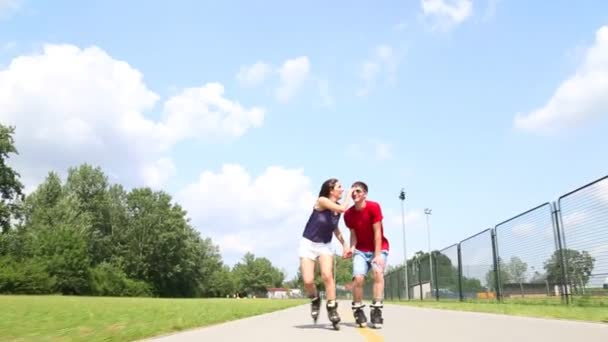Женщина и мужчина катаются на роликах в солнечный день в парке — стоковое видео