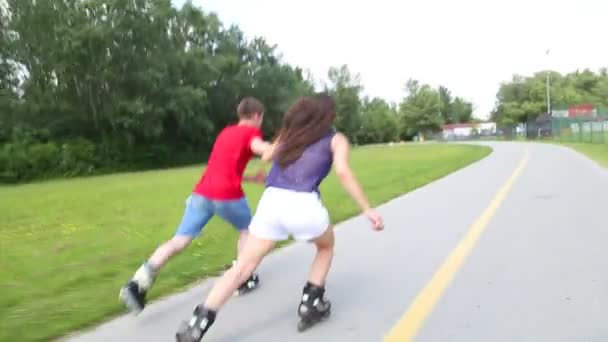 Vrouw en man skaten op een zonnige dag in park — Stockvideo