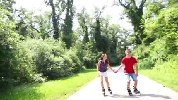 Vrouw en man skaten op een zonnige dag in park — Stockvideo