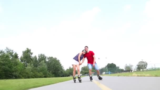Женщина и мужчина катаются на роликах в солнечный день в парке — стоковое видео