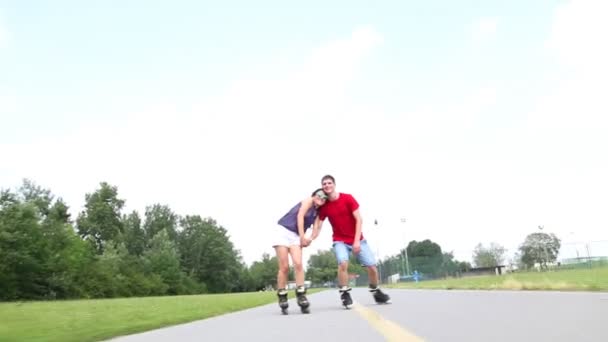 Vrouw en man skaten op een zonnige dag in park — Stockvideo