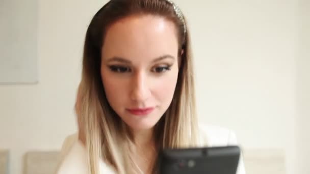 美しい若い女性のミラーとして彼女のスマート フォンを使用して — ストック動画