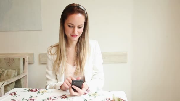 Schöne junge Frau mit ihrem Smartphone — Stockvideo