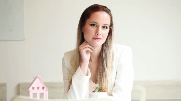 Hermosa joven sentada en el café y sonriendo — Vídeos de Stock