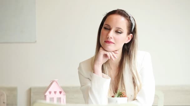 Mooie jonge vrouw zitten in het cafe en glimlachen — Stockvideo