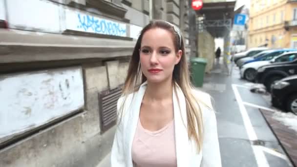 Mooie jonge vrouw loopt door de straat — Stockvideo