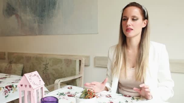 Hermosa joven en un café hablando — Vídeos de Stock