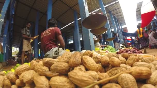 Арахис и человек, сидящий на местном рынке — стоковое видео