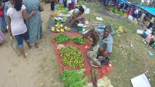 Man sitting and selling at the Sunday market — Stock Video