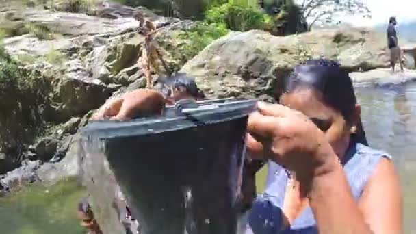 Femme debout dans la rivière verse de l'eau du seau sur elle-même — Video